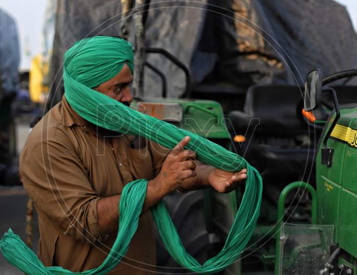 A Sikh farmer tied his turban during a farmers protest at Singhu Border. Farmers are protesting against  new farm laws that they fear will reduce their earnings and give more power to large retailers.
