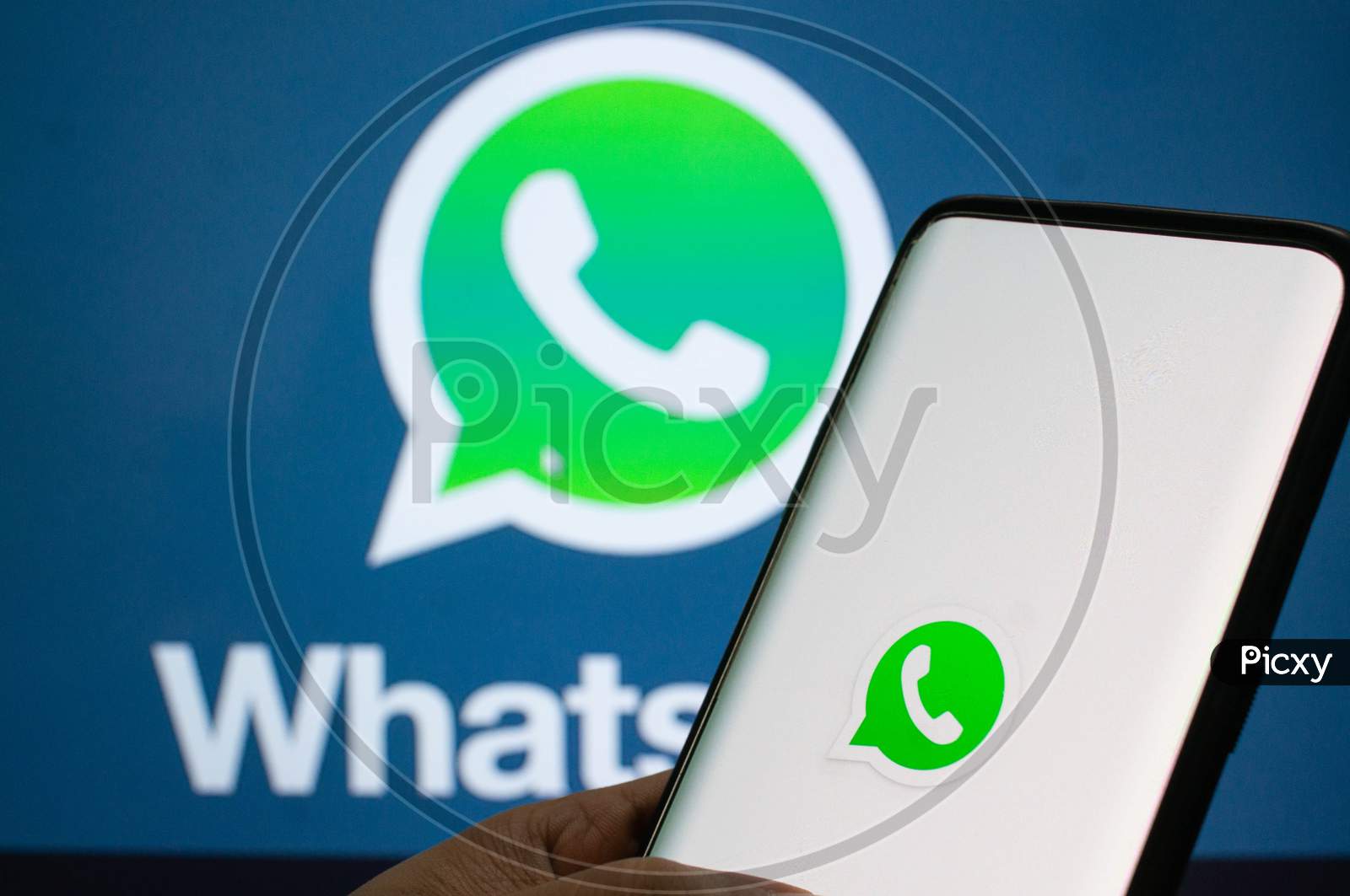 A Mobile Logged Into The Whatsapp Mobile Application Infront Of A Logo Screen