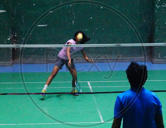 Image of female badminton player  smashing shuttlecock in training session