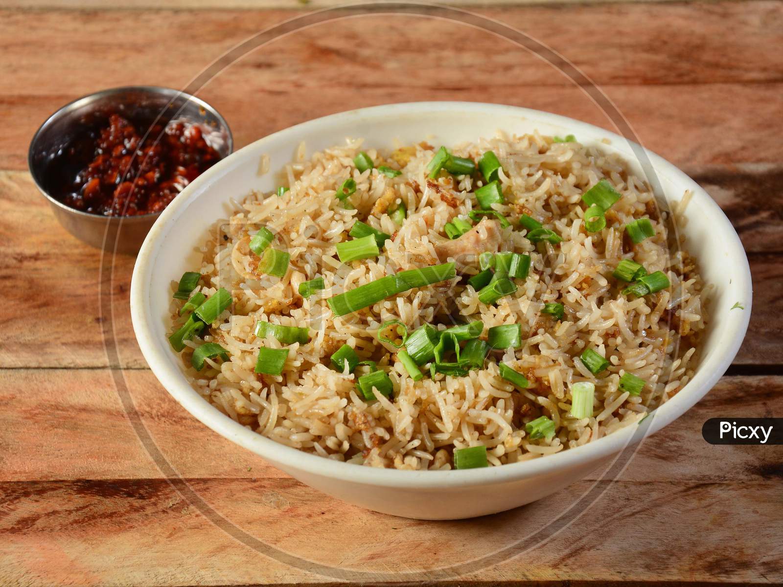 Indian Cuisine Healthy And Tasty Chicken Fried Rice With Tomato Sauce Served In White Bowl Over A Rustic Wooden Background, Selective Focus