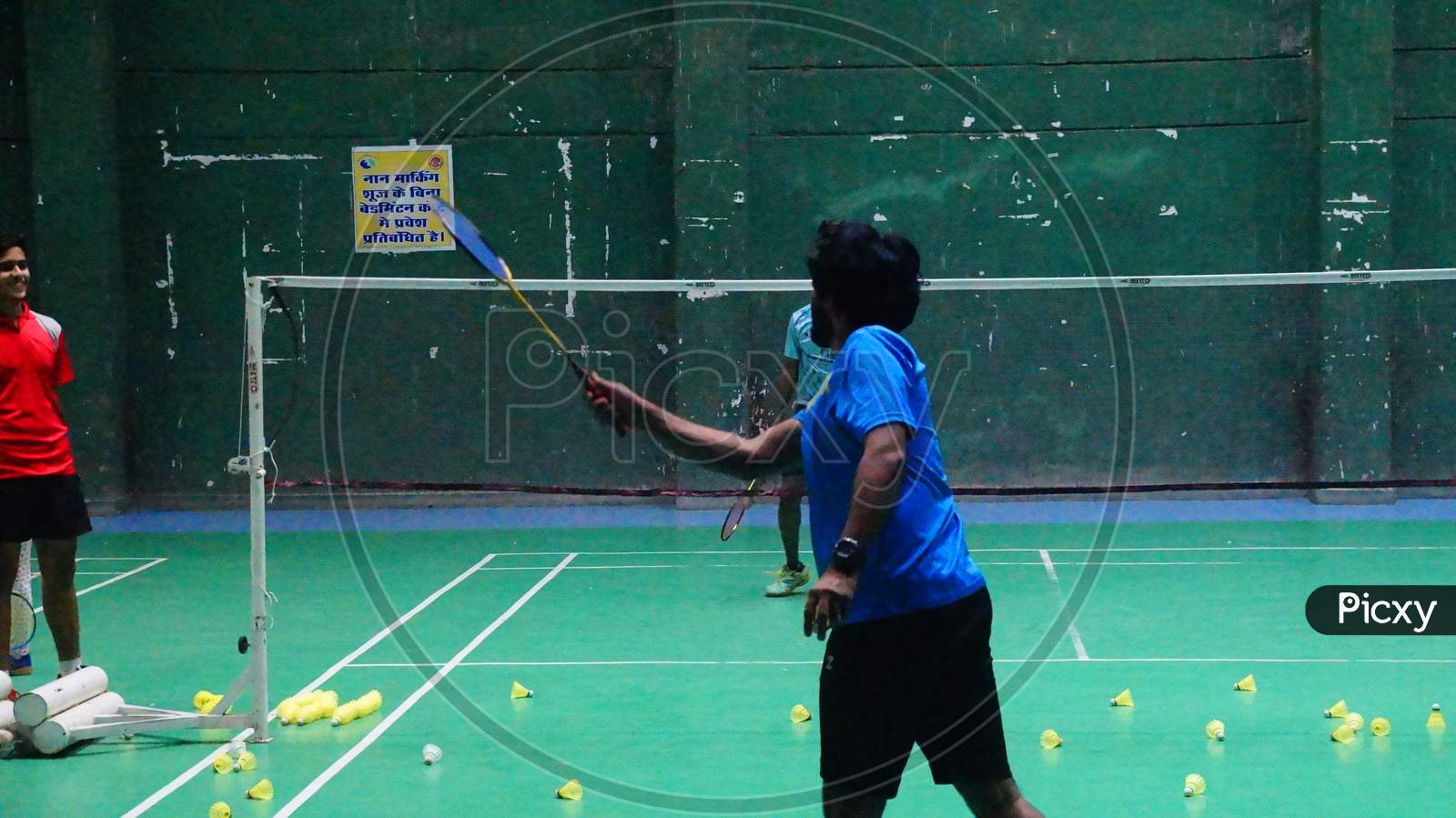 Badminton Coach conducting rally practice with trainee badminton player