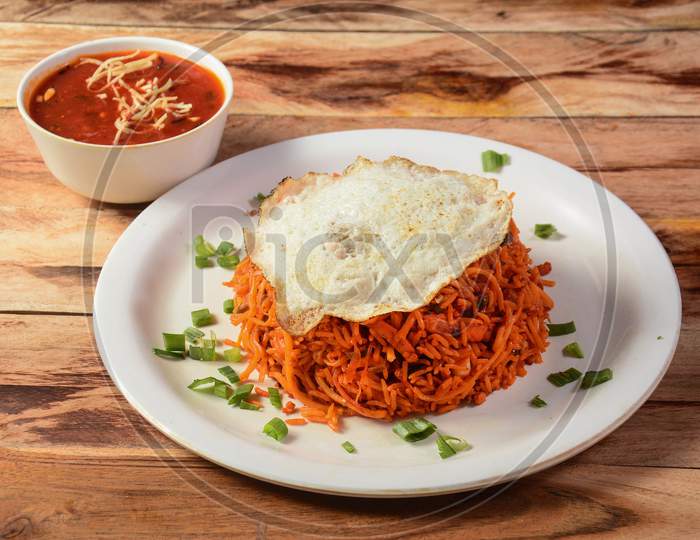 Triple Schezwan Fried Rice Is A Lip Smacking Complete Meal Combination Of Rice, Chicken,Egg And Crispy Fried Noodles Served With Spicy And Fragrant Schezwan Gravy, Indian Cuisine, Selective Focus