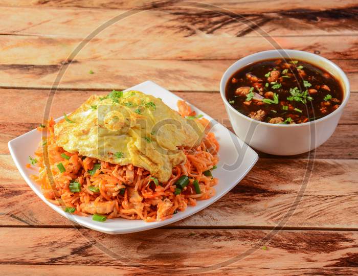 Triple Schezwan Fried Rice Is A Lip Smacking Complete Meal Combination Of Rice, Chicken,Egg And Crispy Fried Noodles Served With Spicy And Fragrant Schezwan Gravy, Indian Cuisine, Selective Focus