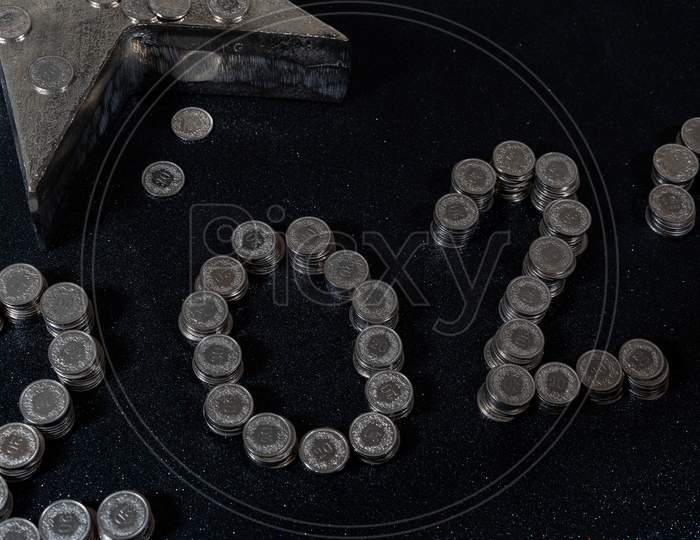 High Angle View Of New Years 2021 As Swiss Coins On A Black Background.