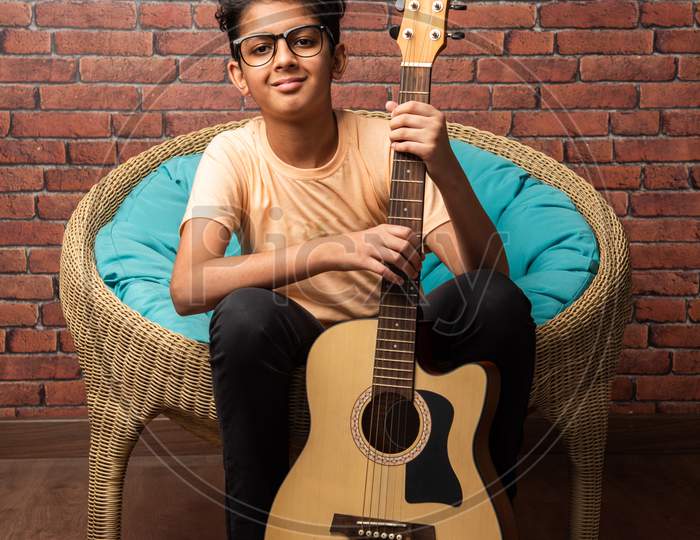 Indian Asian Little Boy Playing Music On Guitar