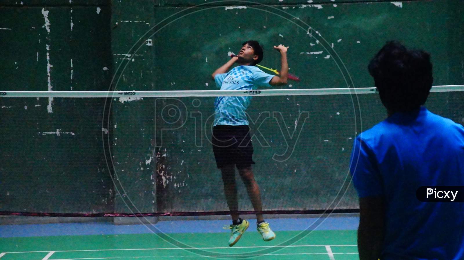 Image of Image of new badminton player attempting jump smash in multi shuttle strokes practice-EM653119-Picxy
