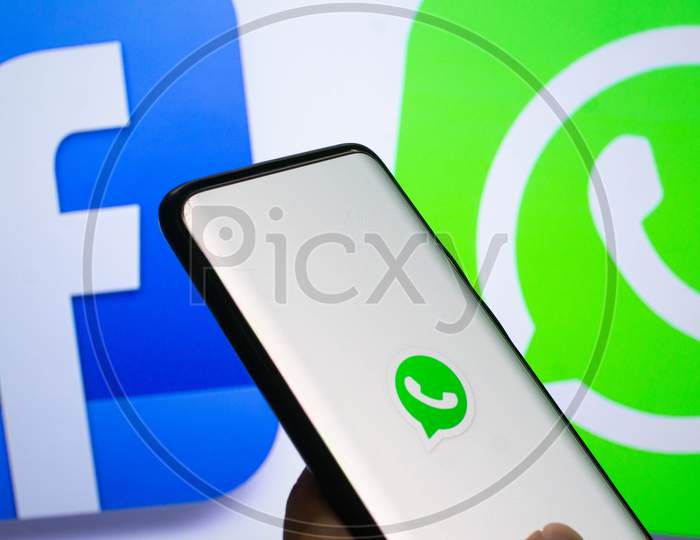 A Mobile Logged Into The Whatsapp Mobile Application Infront Of A Logo Screen