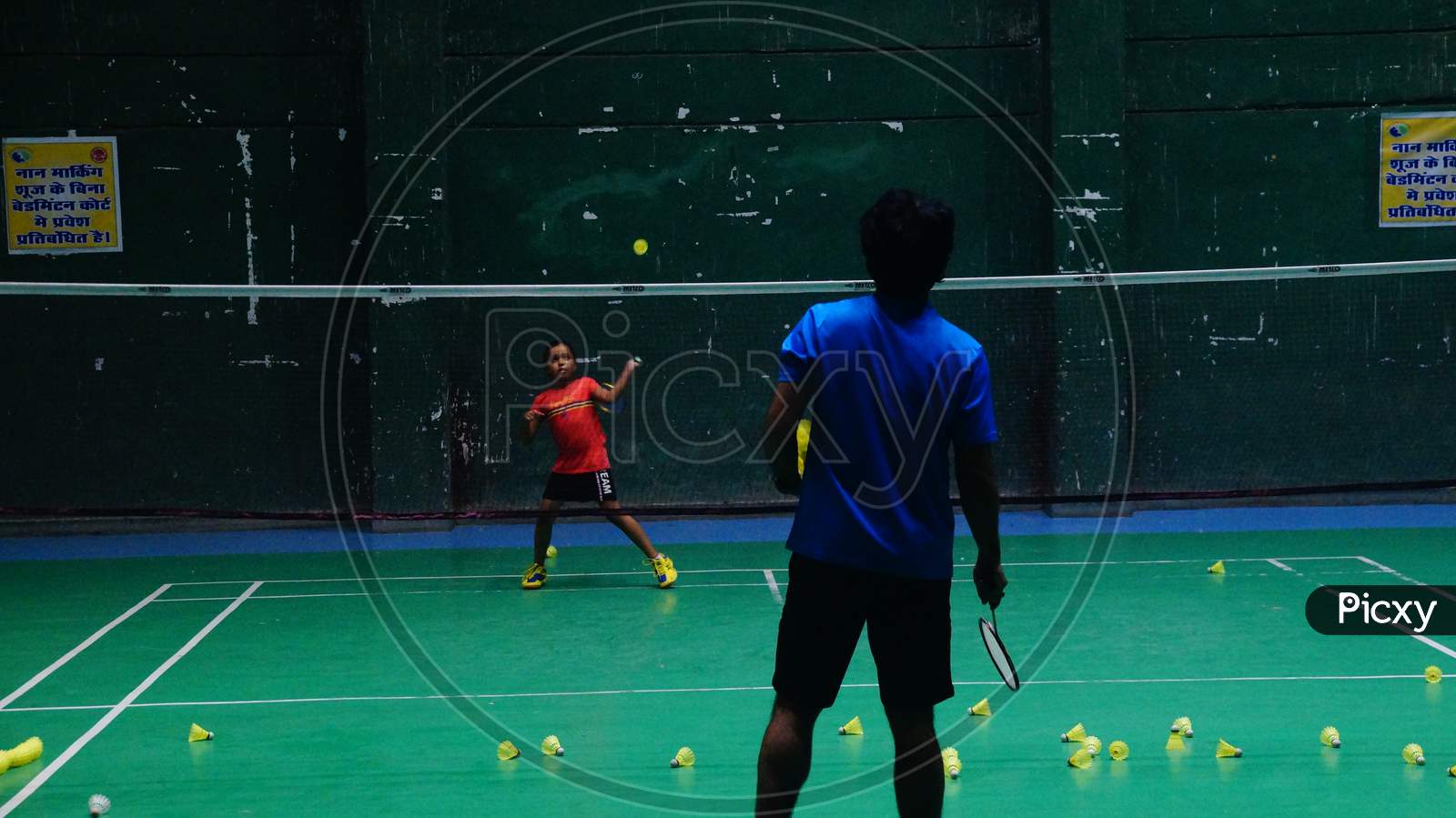 Young badminton trainee learning basic strokes