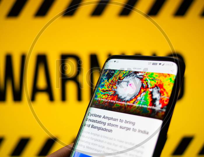 Mobile Phone Logged Into Photo Of Cyclone With Warning Background