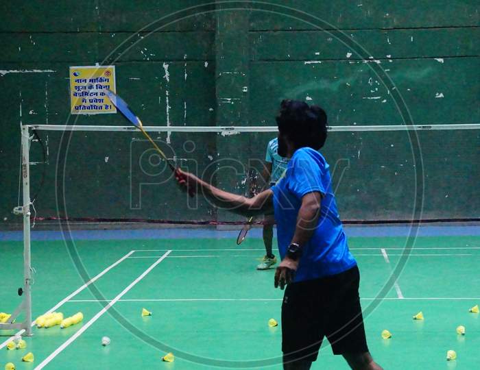 Badminton Coach conducting rally practice with trainee badminton player