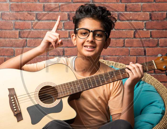 Indian Asian Little Boy Playing Music On Guitar