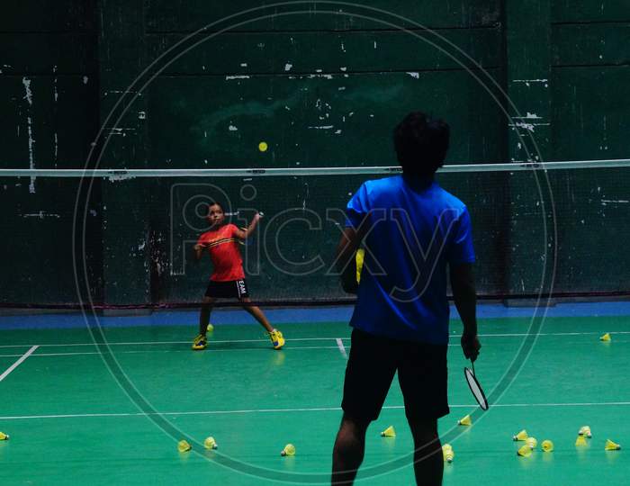 Young badminton trainee learning basic strokes