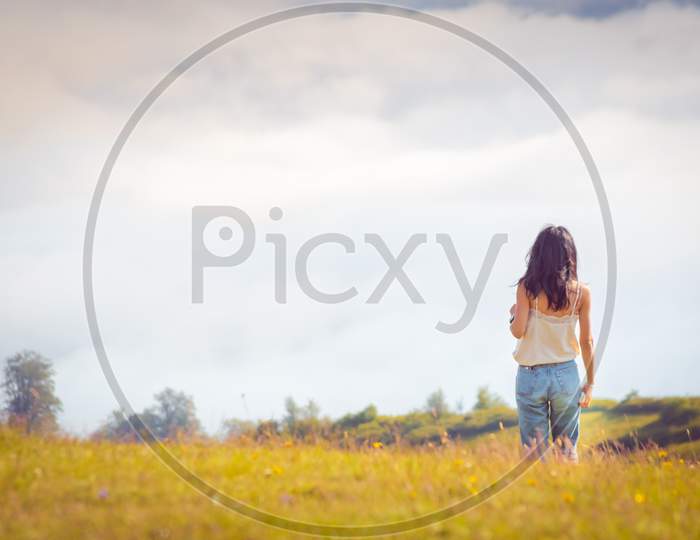 Woman Stands In Distance With View Of Clouds .Blank Space Background