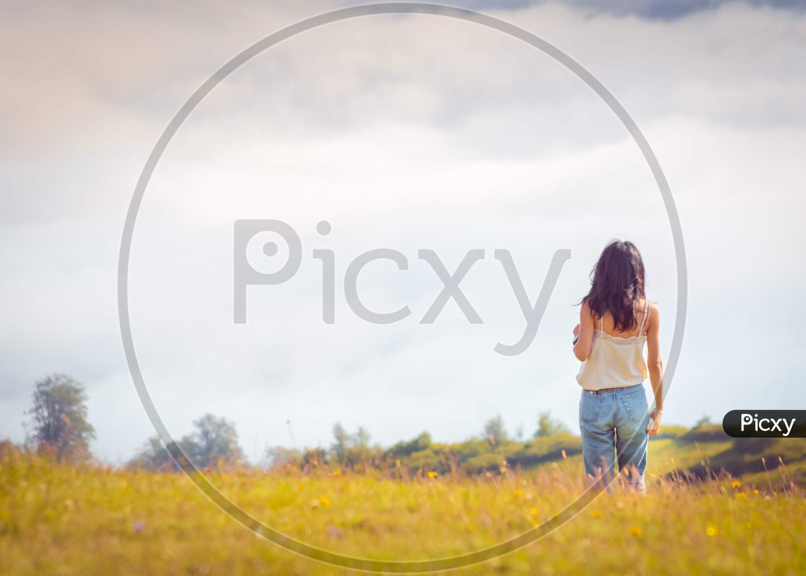 Woman Stands In Distance With View Of Clouds .Blank Space Background