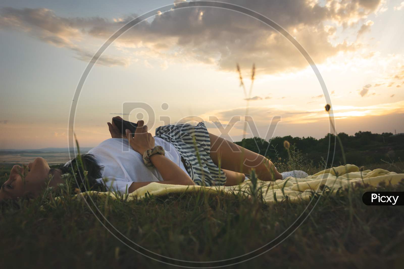 Young Caucasian Happy Woman Lays On The Blanket In Love Posing With Nature Background