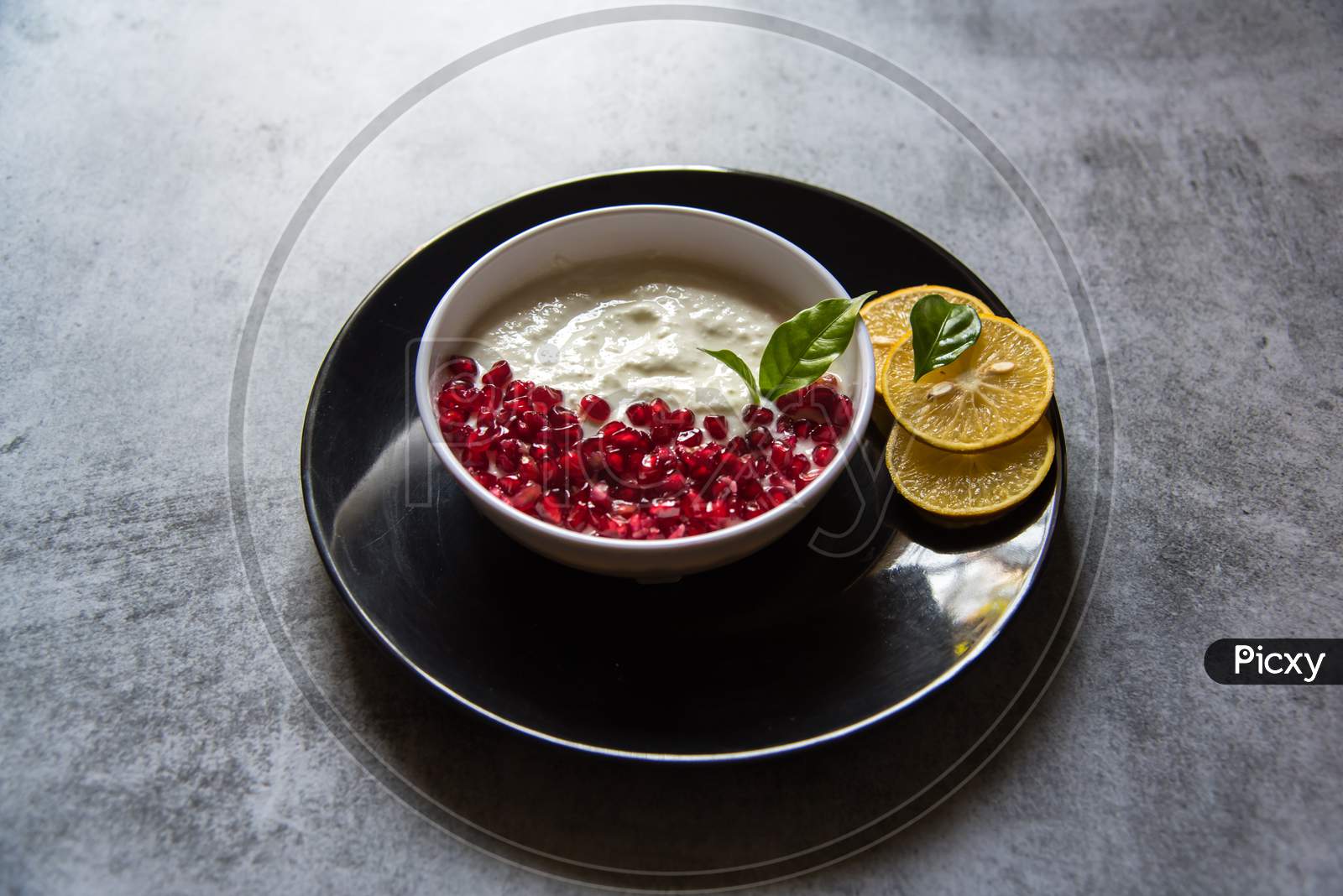Pomegranate seeds and fresh yogurt in a bowl