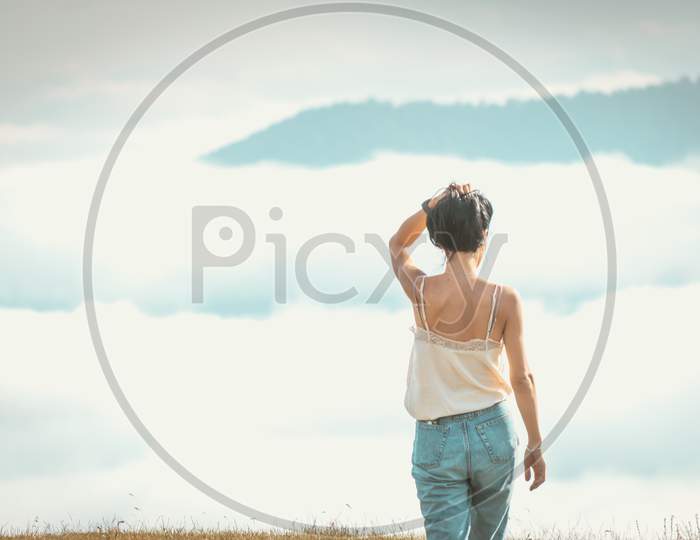 Woman Relaxed Walks Towards The Cloudscape In Pristine Nature. Concept Of Freedom And Life