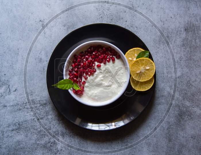 Pomegranate seeds on curd along with fresh fruit ingredients