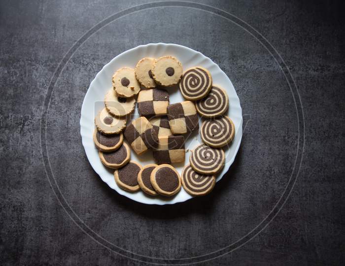 Top view of variety of cookies in a plate on a background