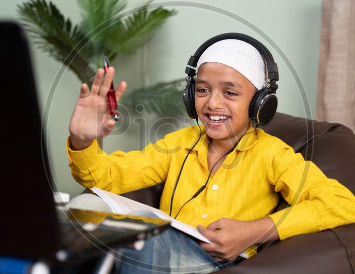 Muslim Kid Busy On Online Class By Making Video Call On Laptop - Concept Of New Normal, E-Learning, Virtual Education And Home Schooling Due To Coronavirus Or Covid-19 Pandemic