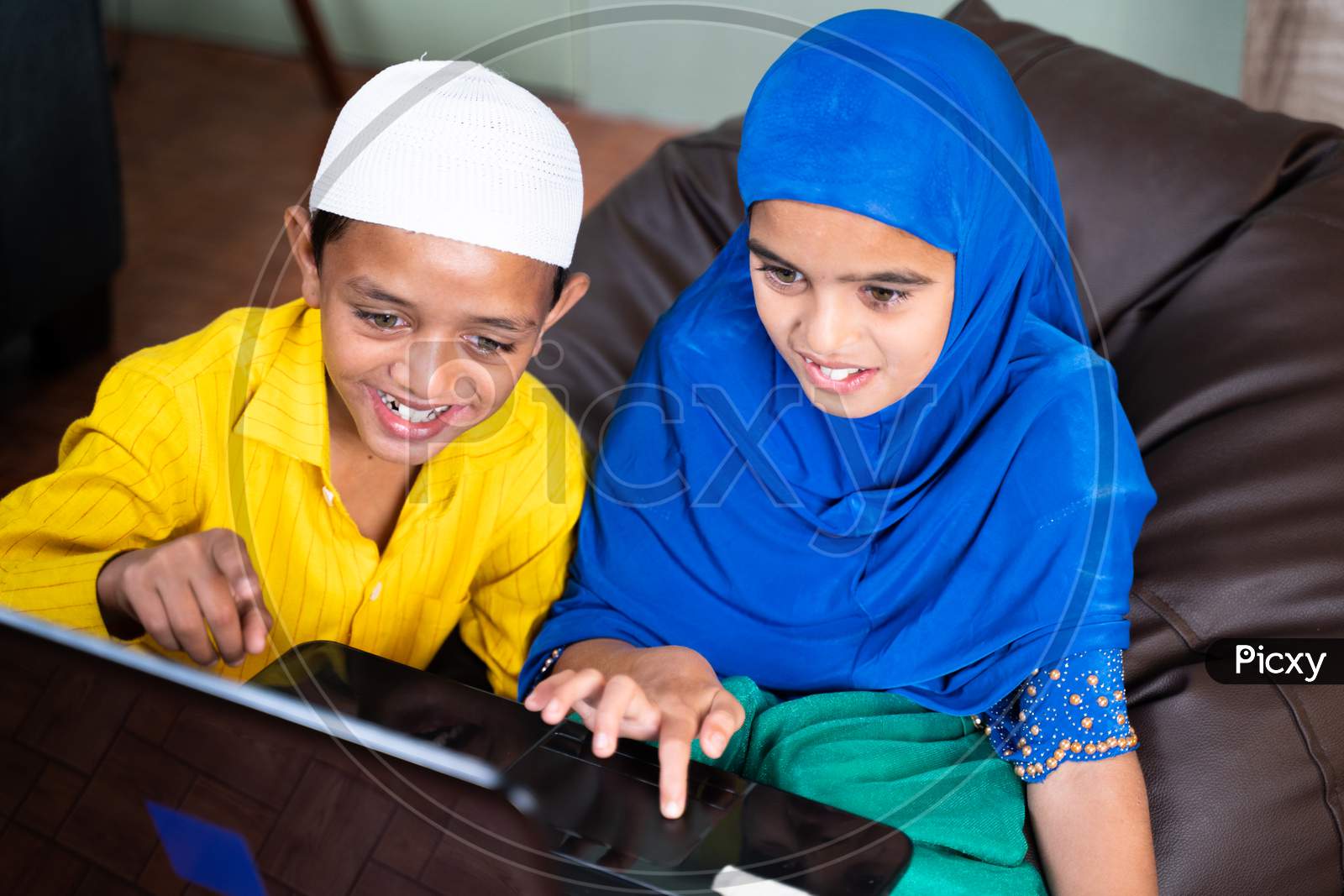 Two Muslim Teenager Kids Excited Over Using Laptop At Home - Concept Of Kids Using Modern Technology And Internet.