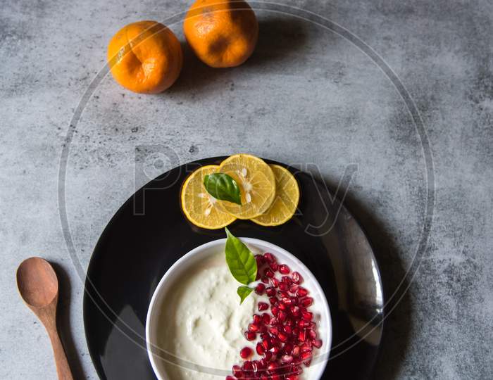 View from above of fresh curd and pomegranate seeds in a bowl along