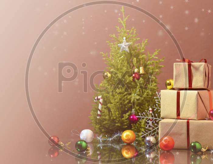 christmas tree with colorful balls and gift boxes over dark background