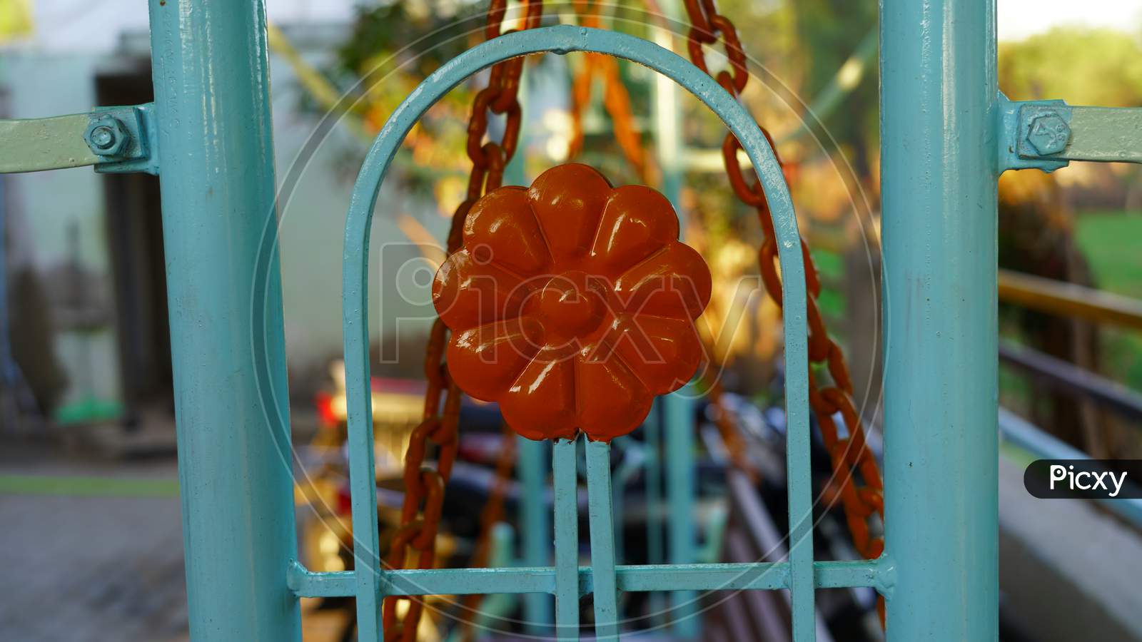 The Fragment Of New Decorated Iron Fence Security Gate View. Attractive Red Colored Round Design In Iron Fence.