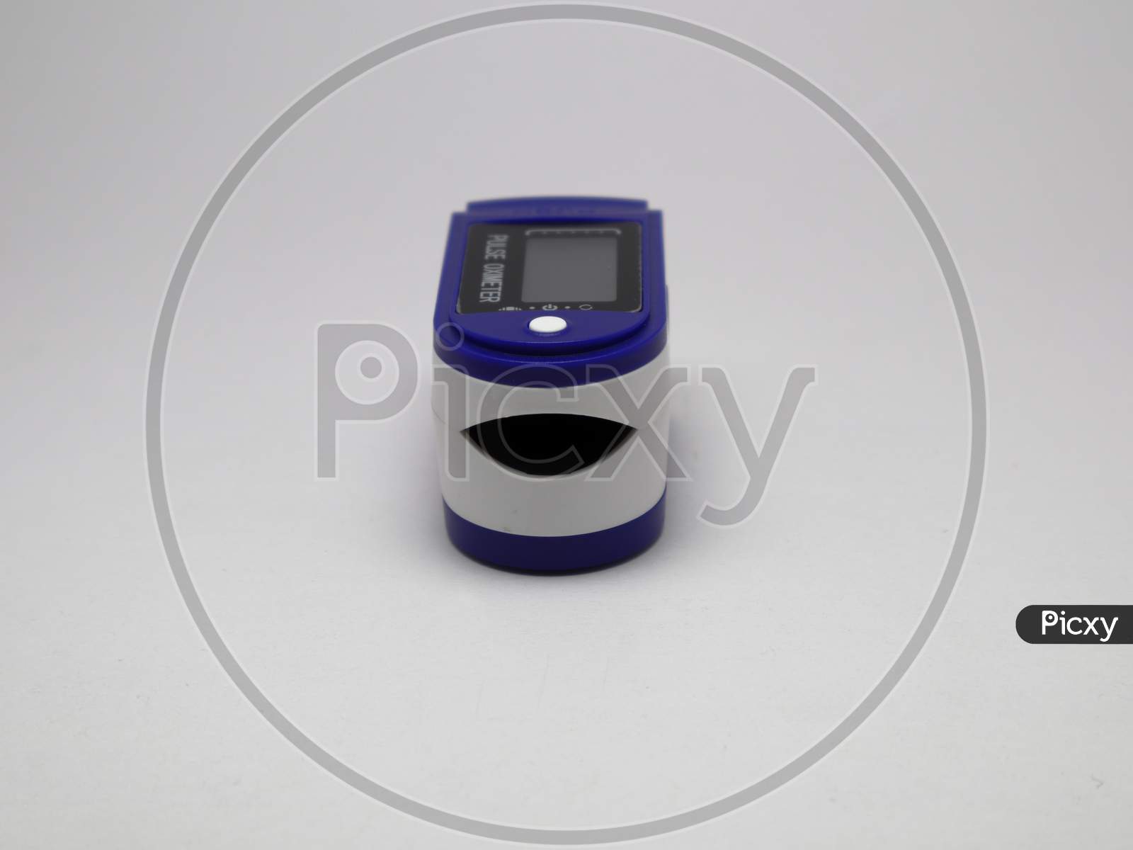 Blue and white portable Pulse Oximeter sensor to monitor oxygen level of a person and pulse rate of a person with white background and selective focus