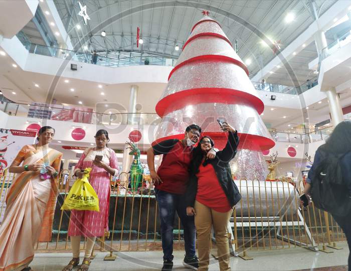People take pictures in front of Christmas decorations inside a mall, amid the spread of the coronavirus disease (COVID-19) in Mumbai, India, December, 2020.