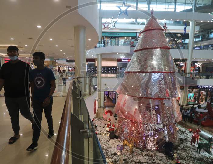 People wearing protective mask walk near Christmas decorations inside a mall, amid the spread of the coronavirus disease (COVID-19) in Mumbai, India, December, 2020.