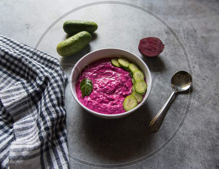 Close up of healthy beetroot dip in a bowl along with condiments