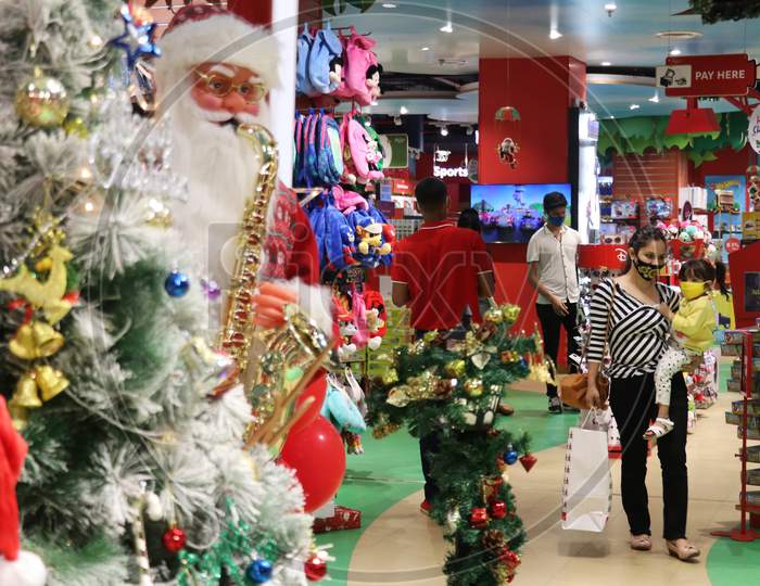 People wearing protective masks walk past Christmas decorations inside a mall, amid the spread of the coronavirus disease (COVID-19) in Mumbai, India, December, 2020.