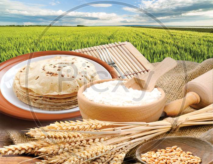 Wheat Flour, Chapati, Roti, Bunch Of Wheat Ears, Dried Grains, Flour In Terracota Bowl On Wheat Farm Background. Cereals Harvesting, Bakery Products.