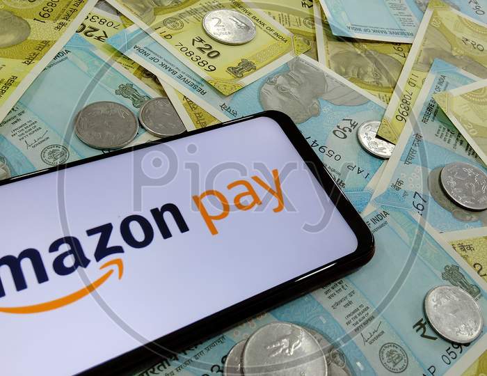 Tamilnadu, India- December 22 2020:Indian currency notes along with Amazon pay logo on a smart phone depicting Amazon pay