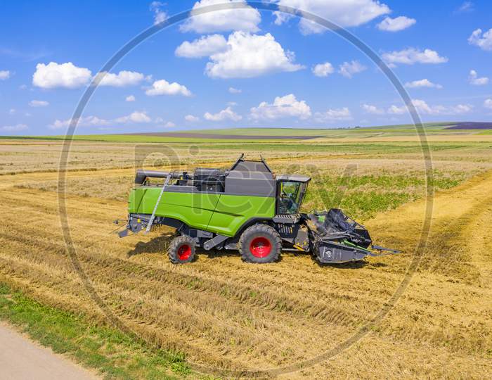 Combine Harvester Working In Wheat Field