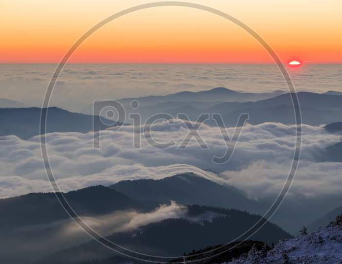Scene From Mountain Peak With Low Clouds