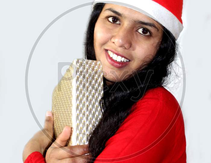 Christmas women, Women with christmas hat expressing emotions with surprise gift, Christmas Celebration over on green background, Selective focus with blur.