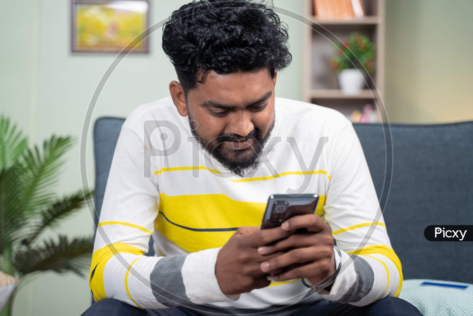 Young Man Smiling By Reading Funny Message Or Sms On Mobile Phone - Concept Of Using Social Media, Internet And Entertainment Lifestyle.