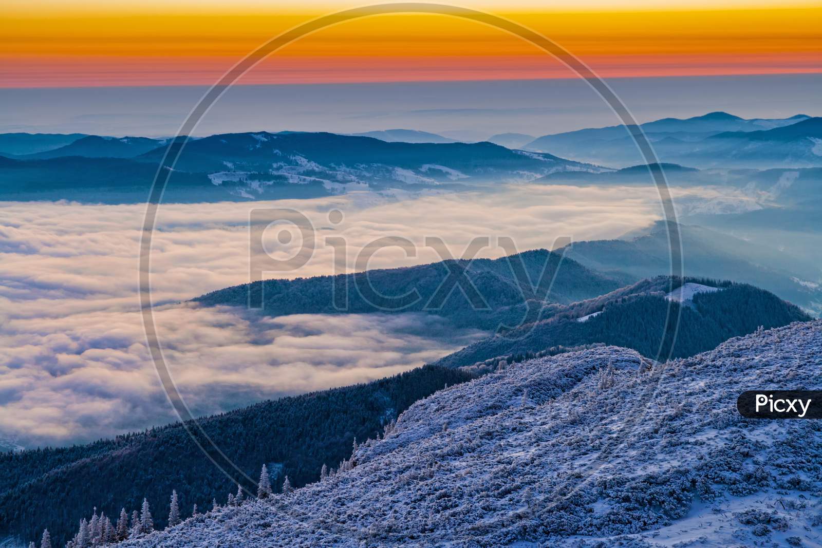 Winter Sunrise On Mountain Mist In Valley
