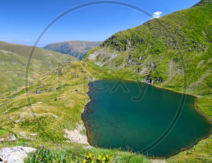 Clear Alpine Lake Scene In Romanian Carpathians