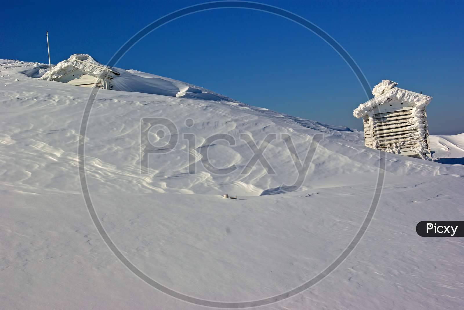 Snow Covered Weather Station On Mountain Top