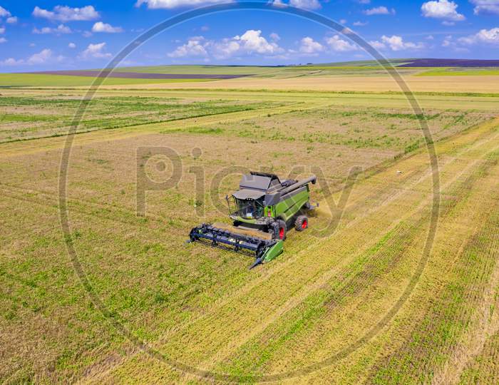 Aerial View Of Working Combine In Cereal Field