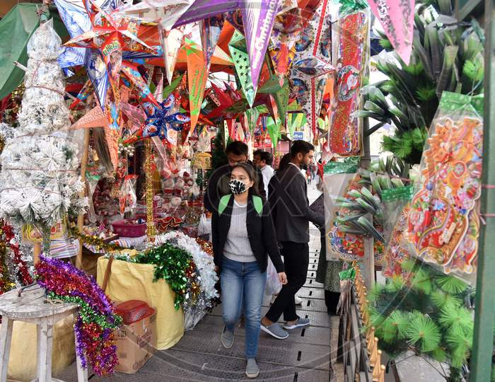 eople walk past a shop selling decorative items ahead of Christmas, in Guwahati , India on Dec 21,2020