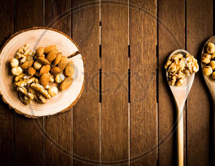 Mix Of Almonds, Walnuts And Hazelnuts On A Wooden Table