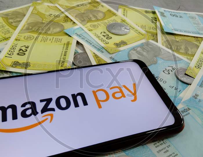 Tamilnadu, India- December 22 2020:Indian currency notes along with Amazon pay logo on a smart phone depicting Amazon pay
