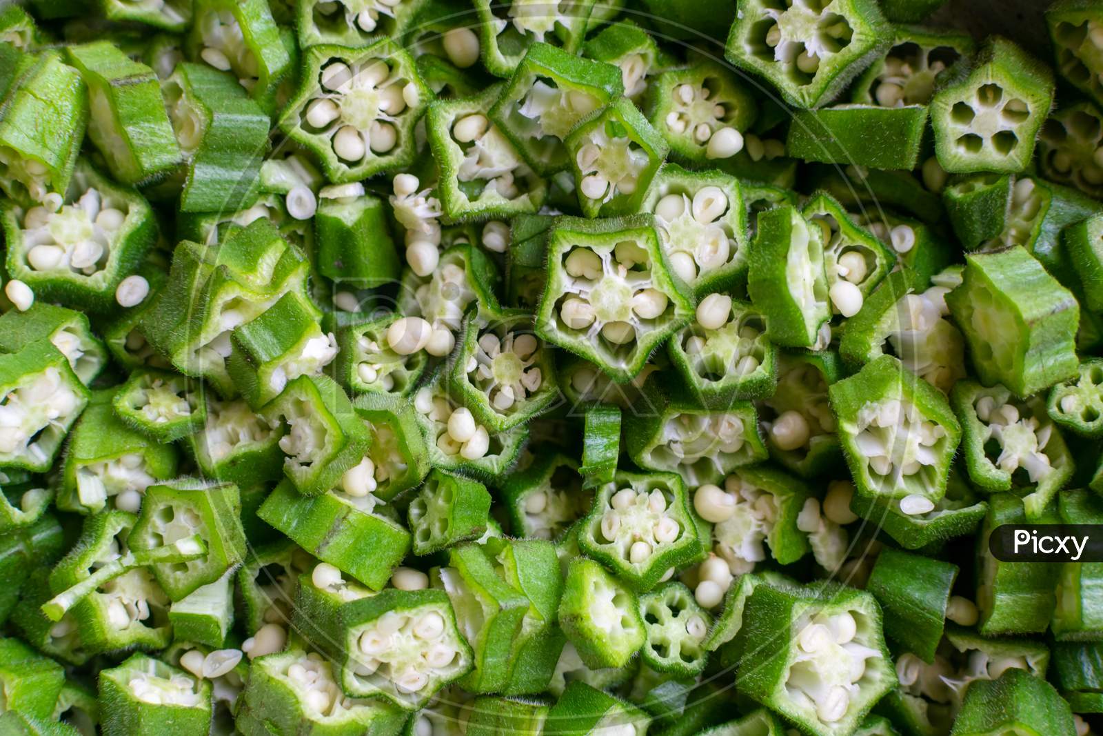 Background Of Freshly Chopped Green Vegetable Okra Or Okro Also Known As Ladies Fingers Or Orhro In Many Countries.
