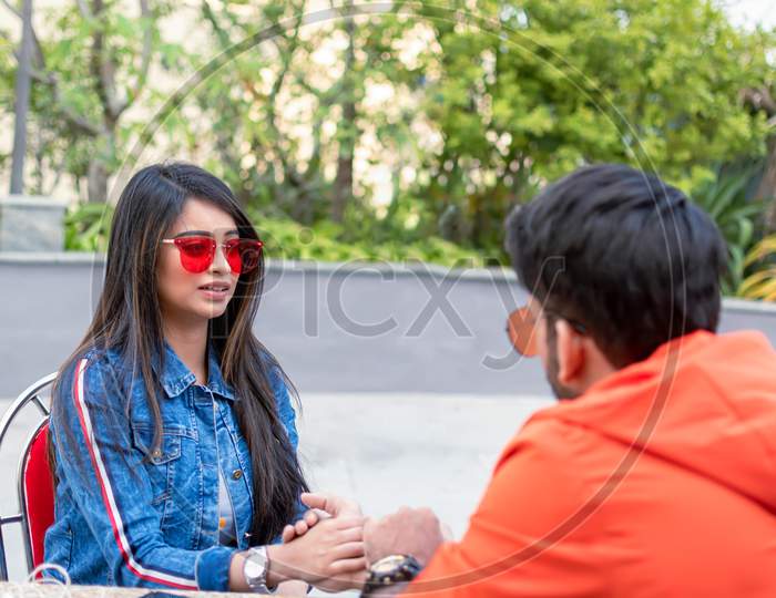 Young Indian Couple In Love Spend Time Together While Sitting At Table In Outdoor Cafe In Kolkata On December 2019