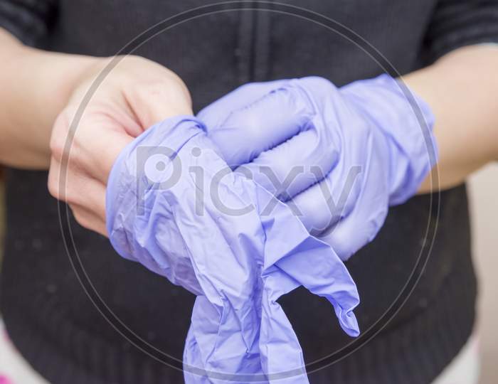 Pulling Surgical Gloves On Hands