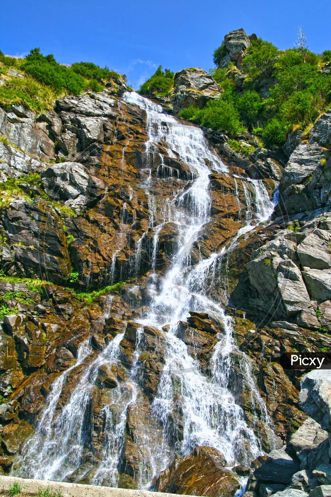 Summer Waterfall In A Rocky Mountain